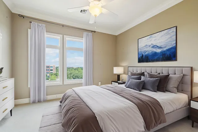 an empty room with chandelier fan and windows
