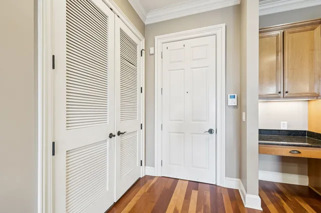 a view of a hallway with wooden floor and closet area