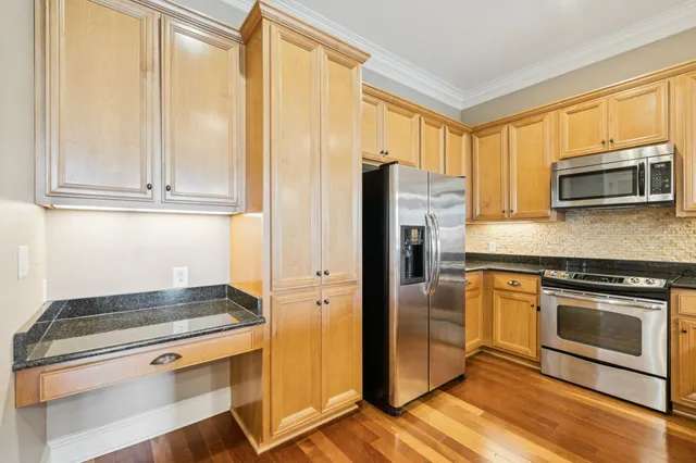 a kitchen with granite countertop a refrigerator stove and microwave
