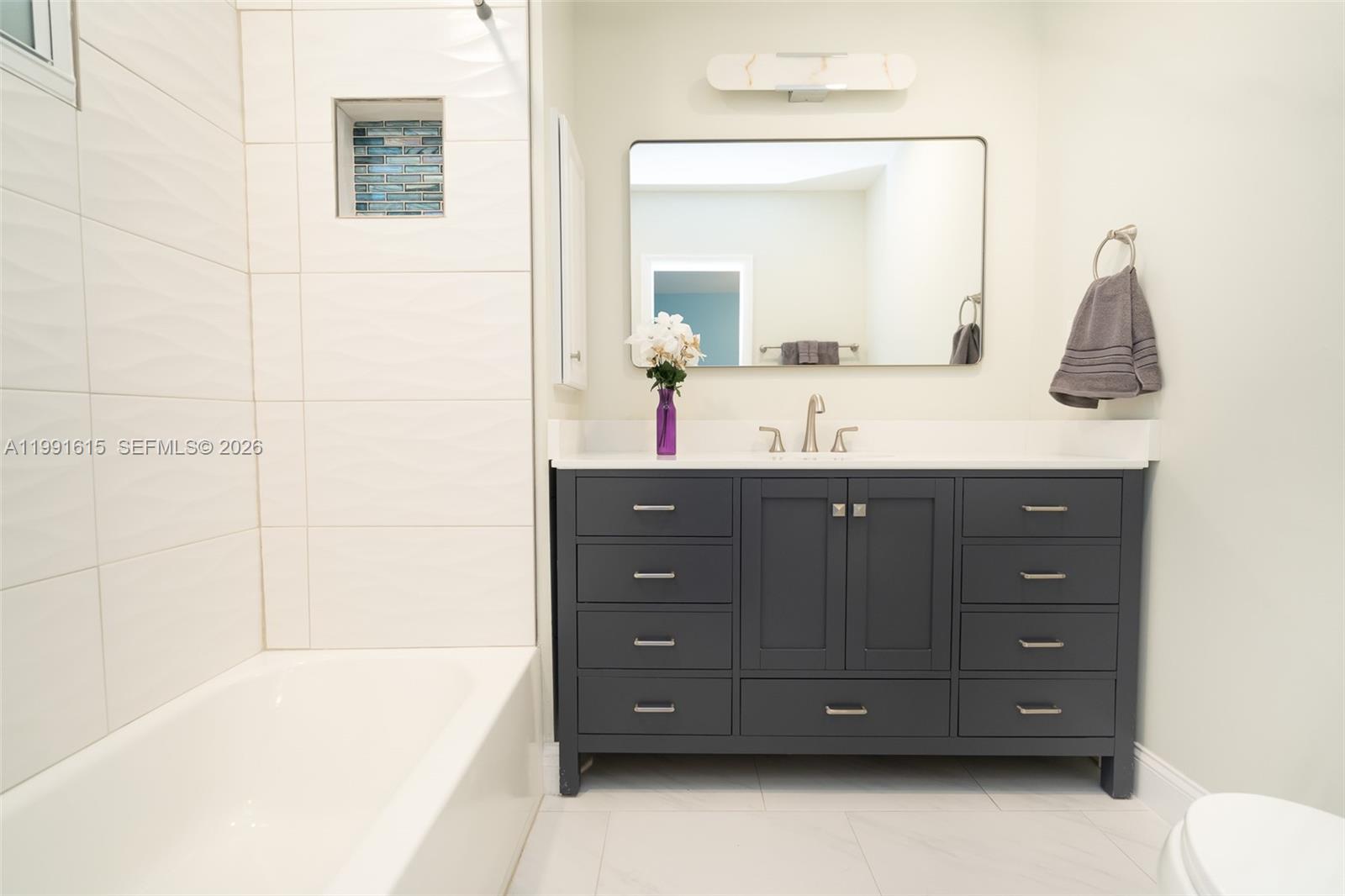 2230 Southwest 60th Court Miami, FL 33155 - Photo 22 of 35 a bathroom with a sink vanity granite tub and a mirror