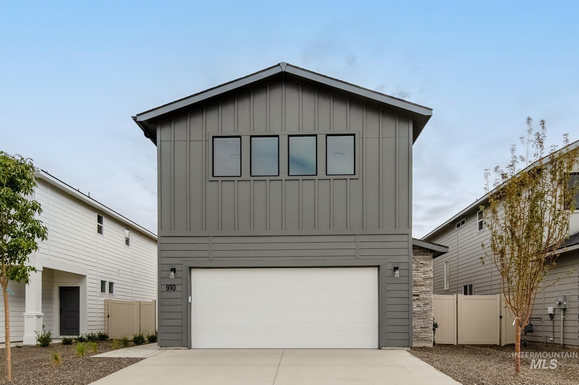 View of front facade with board and batten siding, concrete driveway, and a garage