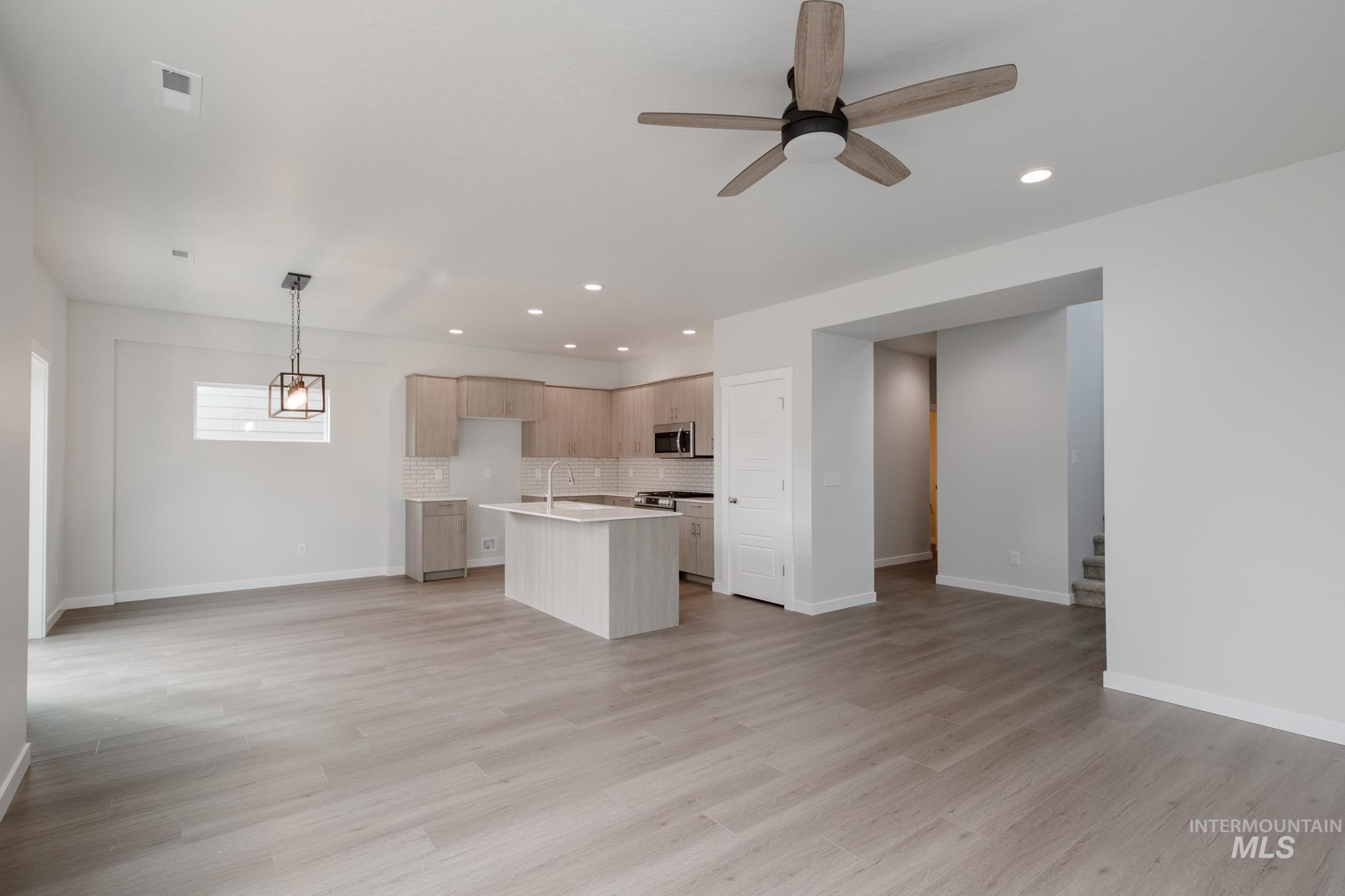 910 North Mirror Creek Way Meridian, ID 83642 - Photo 27 of 27 Kitchen featuring open floor plan, a center island with sink, decorative backsplash, recessed lighting, and hanging light fixtures