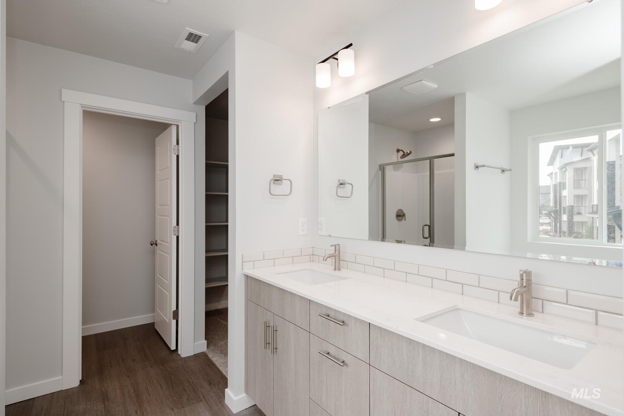 910 North Mirror Creek Way Meridian, ID 83642 - Photo 17 of 27 Bathroom featuring a stall shower, double vanity, dark wood finished floors, a spacious closet, and recessed lighting