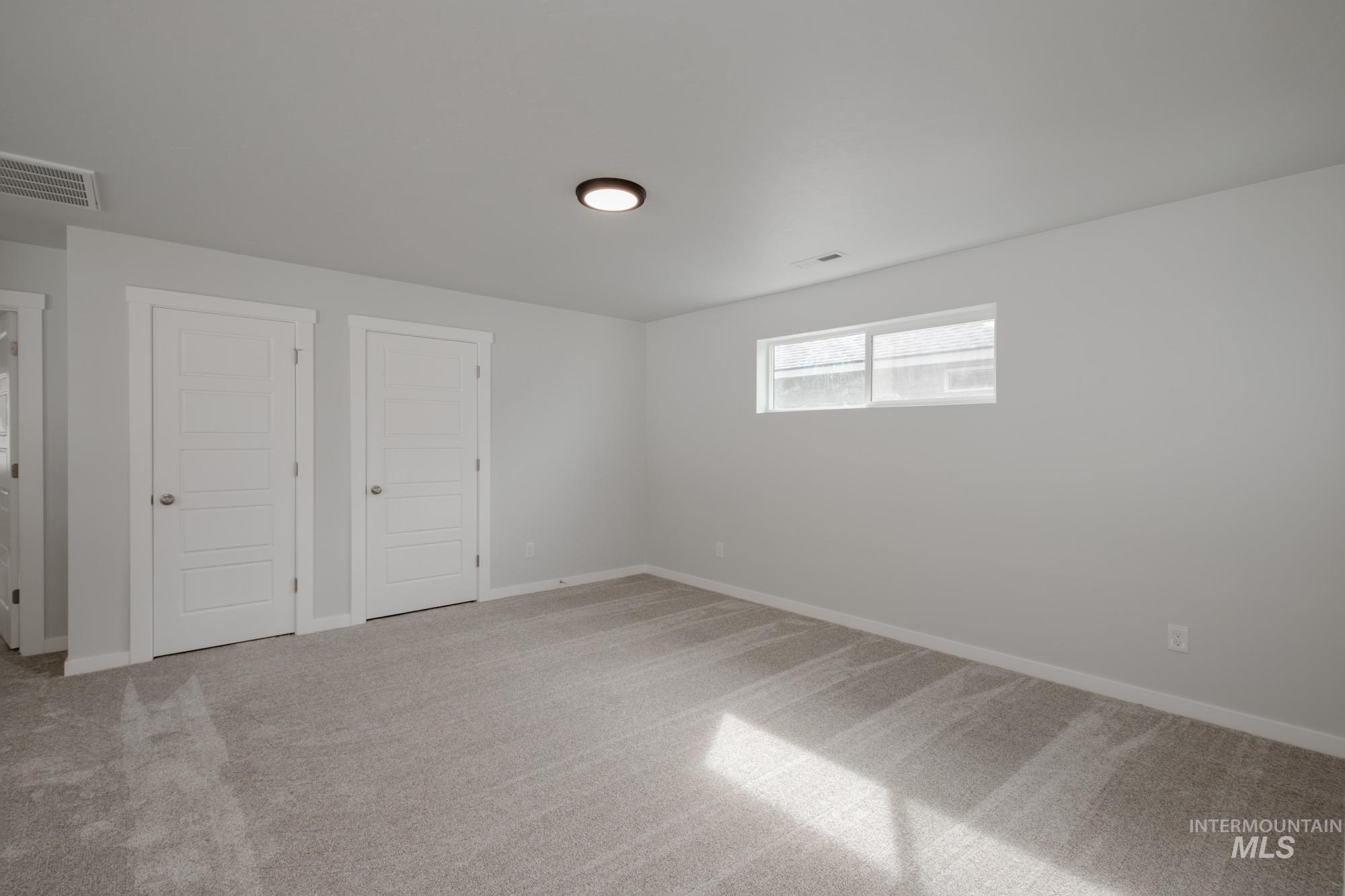 910 North Mirror Creek Way Meridian, ID 83642 - Photo 21 of 27 Unfurnished bedroom with light colored carpet and baseboards