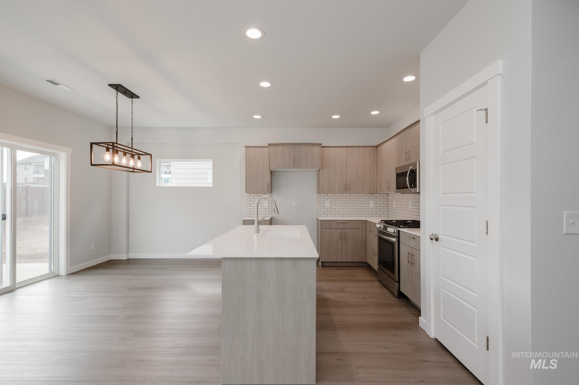 910 North Mirror Creek Way Meridian, ID 83642 - Photo 4 of 27 Kitchen with light brown cabinetry, appliances with stainless steel finishes, decorative backsplash, modern cabinets, and recessed lighting