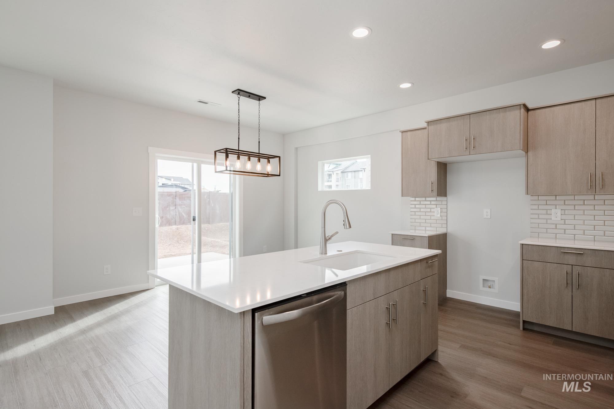 910 North Mirror Creek Way Meridian, ID 83642 - Photo 6 of 27 Kitchen with stainless steel dishwasher, pendant lighting, dark wood-type flooring, recessed lighting, and light stone countertops