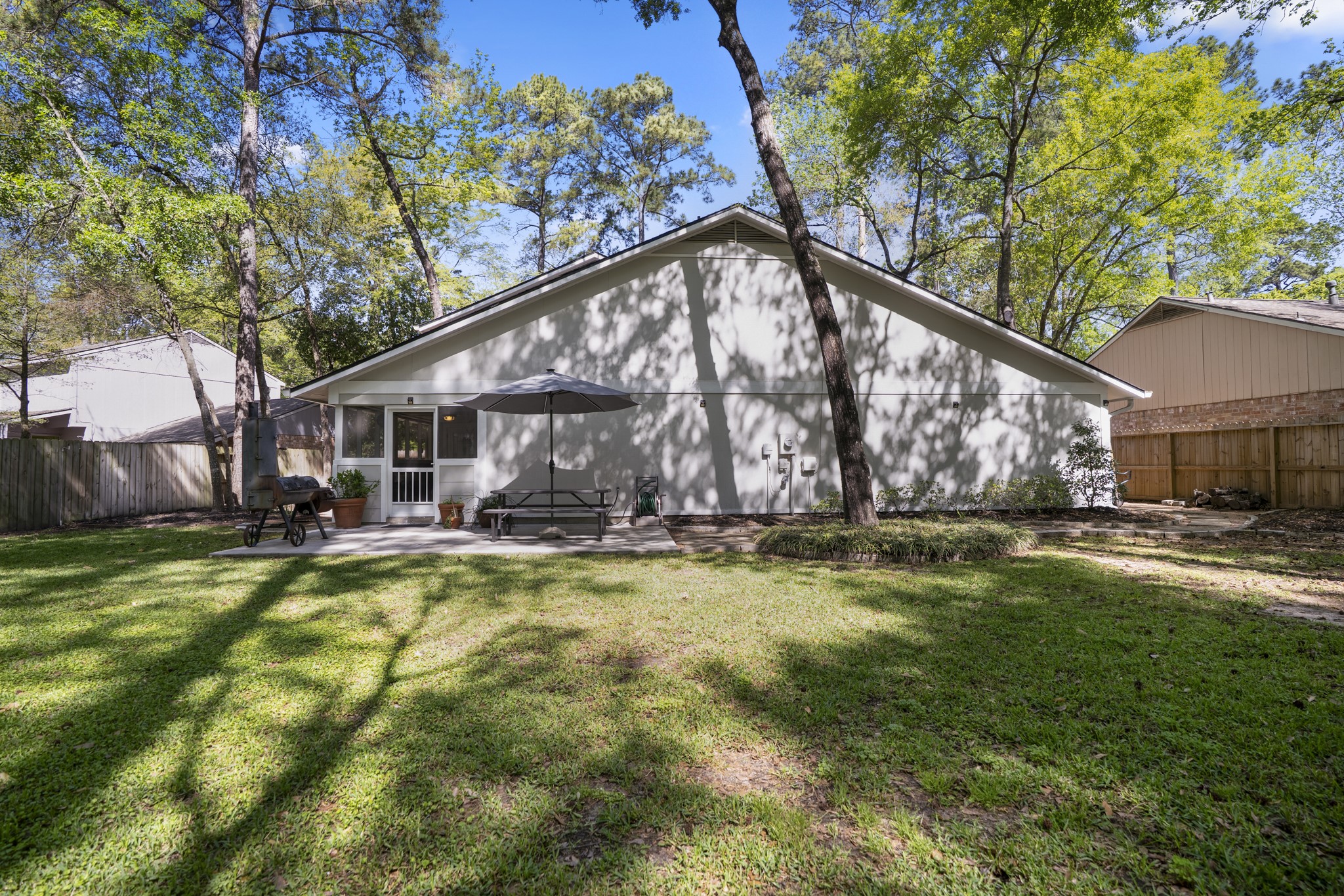 12224 Gun Oak Place Spring, TX 77380 - Photo 2 of 43 Nestled among mature trees, this expansive backyard offers a peaceful setting with shade, privacy, and plenty of space to relax and enjoy the outdoors.