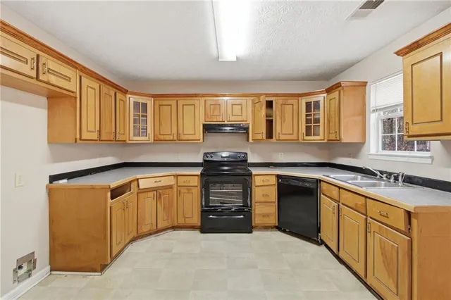 a kitchen with stainless steel appliances granite countertop a stove sink and cabinets