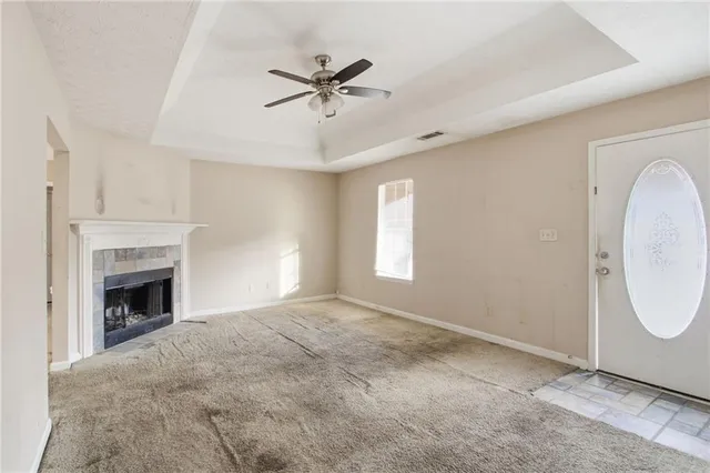 a view of an empty room with a fireplace and a window