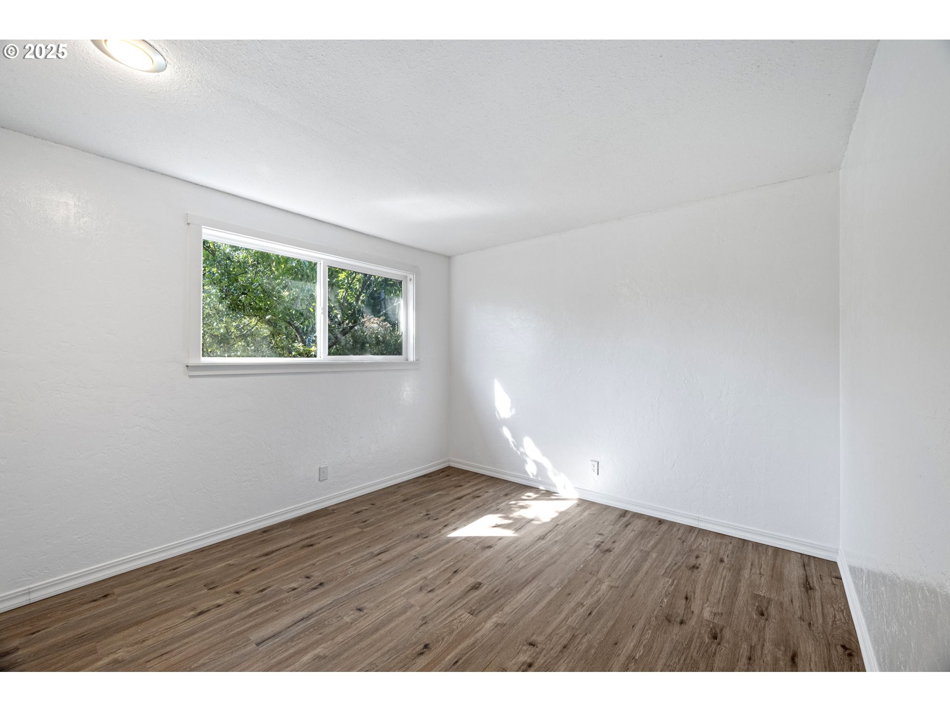 2105 16th Street Florence, OR 97439 - Photo 29 of 48 a view of an empty room with wooden floor and a window