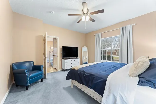 a bedroom with a bed a couch and a flat screen tv