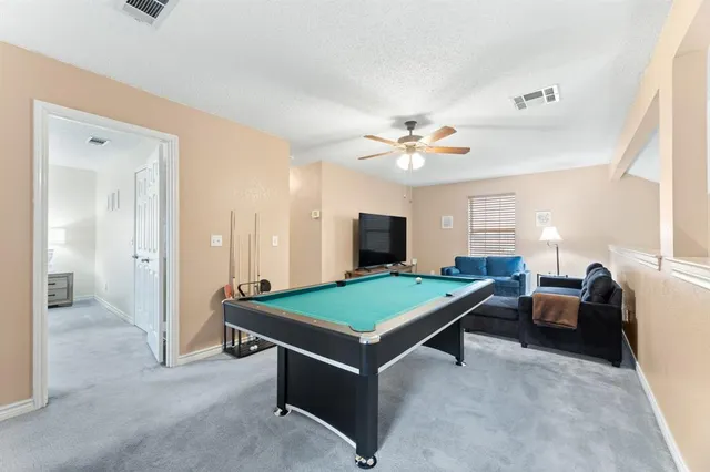a living room with furniture pool table and flat screen tv