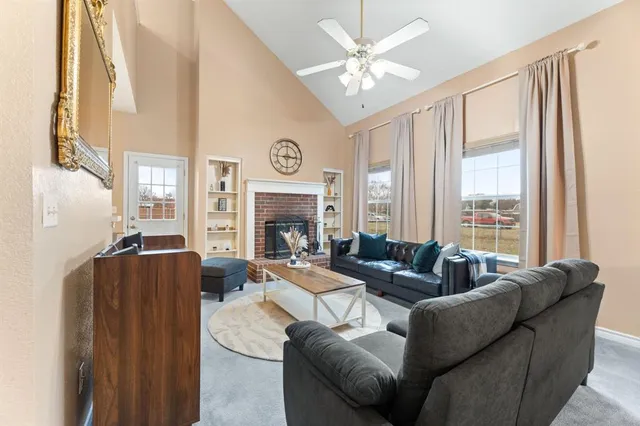 a living room with furniture large window and fireplace