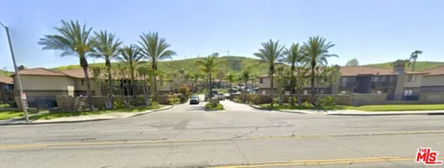 a view of swimming pool with a yard and palm trees