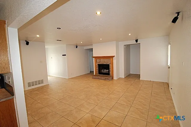 an empty room with fireplace and a window