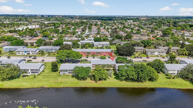 a living room with stainless steel appliances furniture a large window and a bookshelf