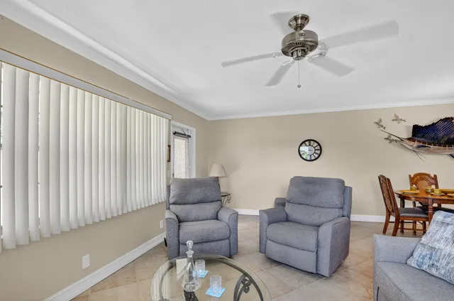 a living room with furniture a flat screen tv and a large window
