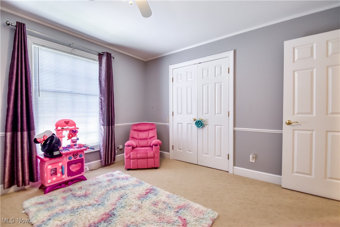 9715 Johnnycake Ridge Road Mentor, OH 44060 - Photo 9 of 50 Carpeted bedroom featuring ornamental molding, ceiling fan, and a closet