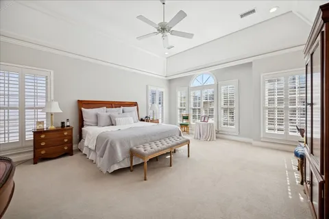 a spacious bedroom with a balcony a bed and a glass door shower