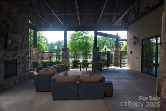 a living room with furniture and a floor to ceiling window next to a yard