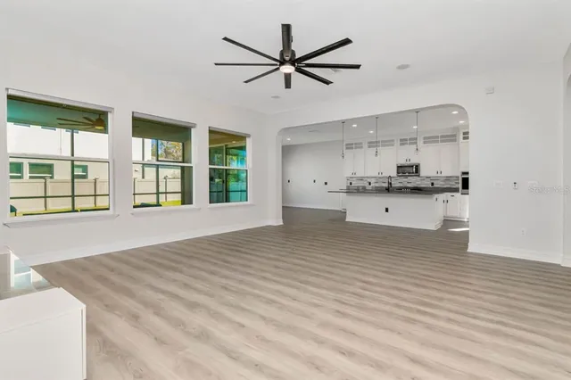 a view of a livingroom with wooden floor and a ceiling fan
