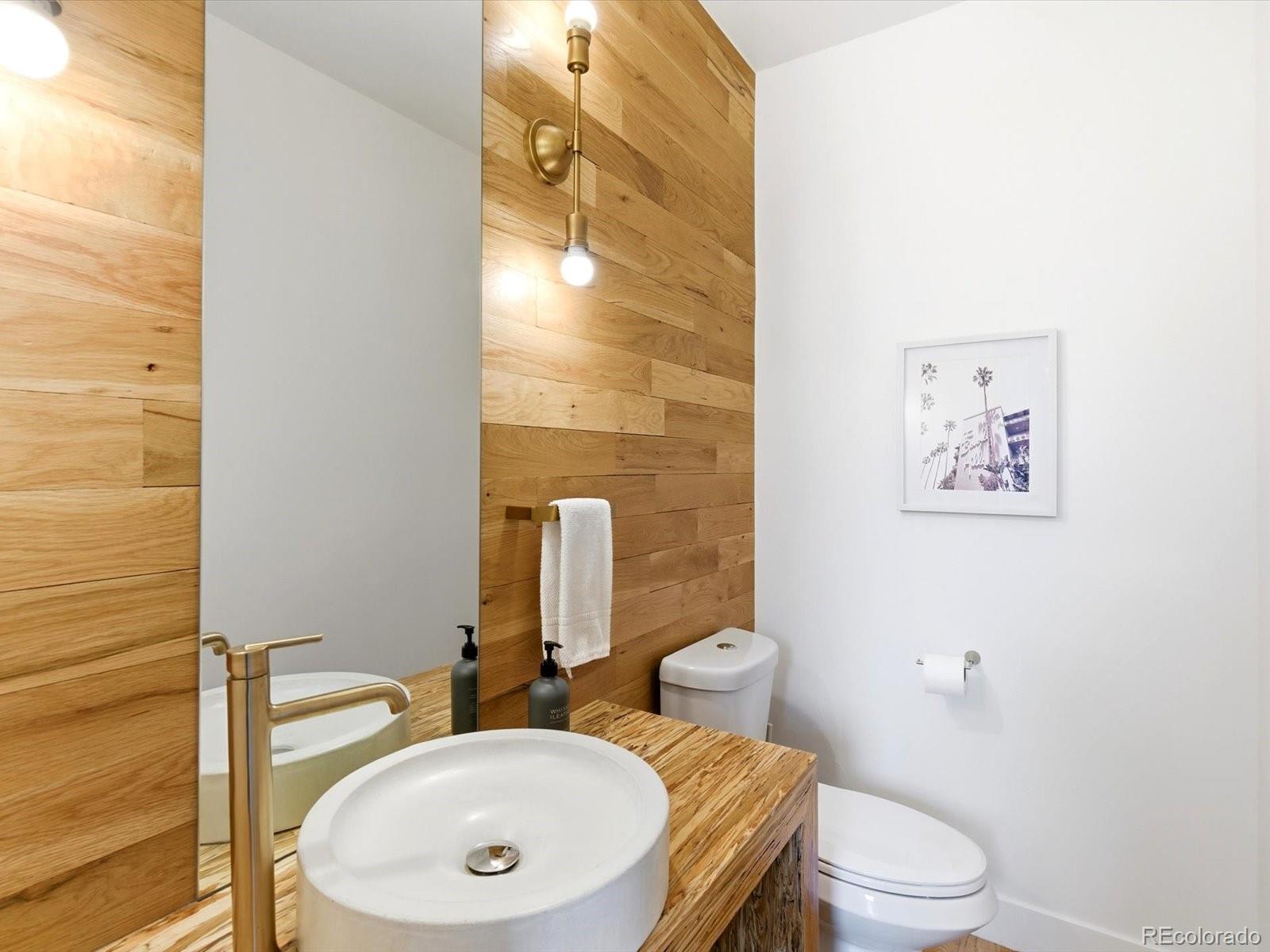 4141 Shoshone Street Denver, CO 80211 - Photo 16 of 50 a bathroom with a granite countertop toilet sink and mirror