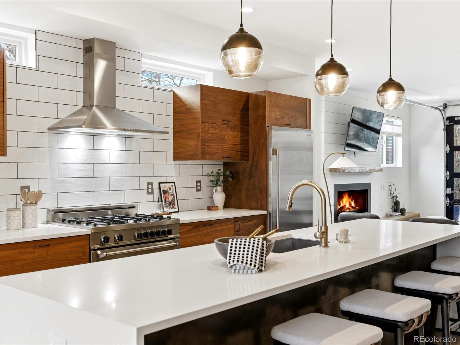 4141 Shoshone Street Denver, CO 80211 - Photo 5 of 50 a kitchen with a sink a stove and a wooden floor