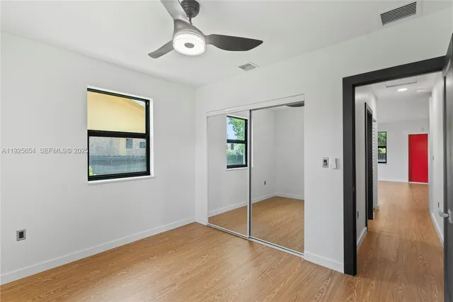 a view of an empty room with closet and a window