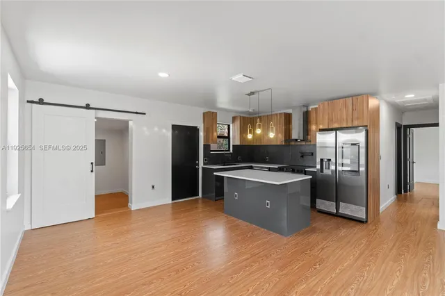 a large kitchen with a refrigerator and a stove top oven