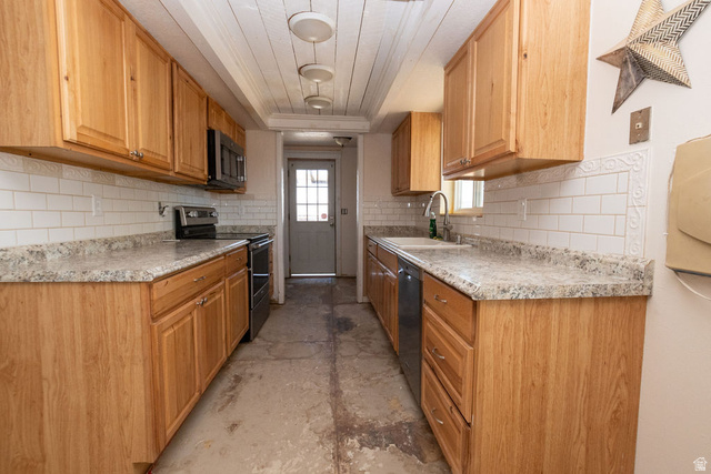 570 West Main Street Beaver, UT 84713 - Photo 8 of 43 Galley-style kitchen featuring light wood cabinetry, stone-look countertops, and white subway tile backsplash