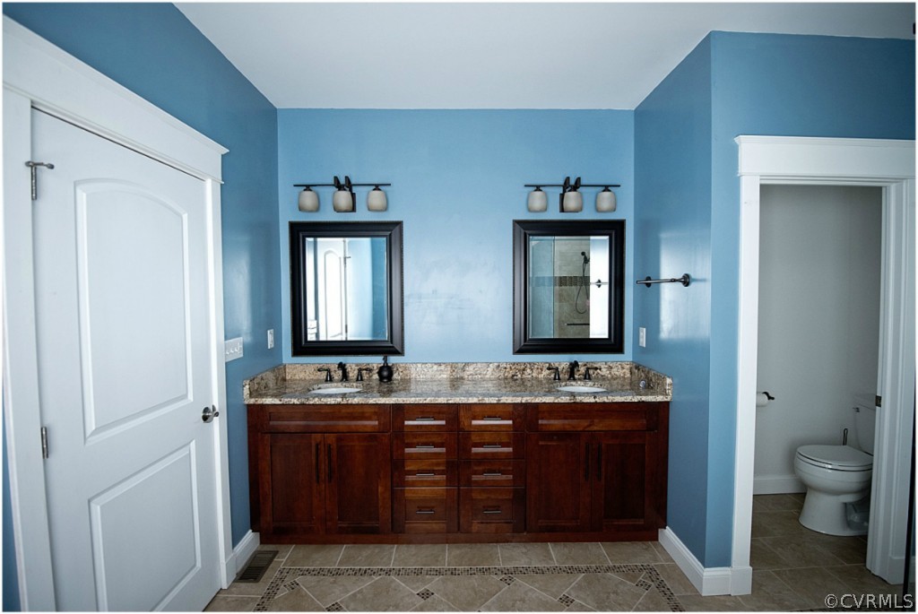 3822 Baldwin Road Chester, VA 23831 - Photo 12 of 22 a bathroom with a granite countertop toilet sink and mirror