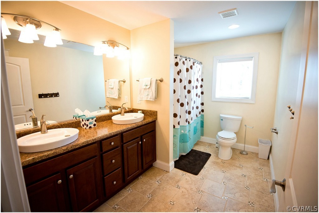 3822 Baldwin Road Chester, VA 23831 - Photo 16 of 22 a spacious bathroom with a double vanity sink toilet and a shower