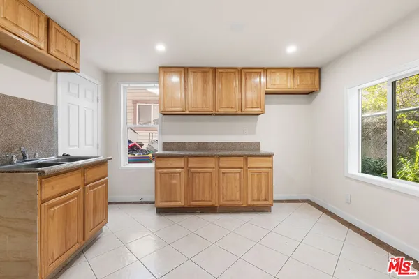 a kitchen with granite countertop a stove sink and cabinets