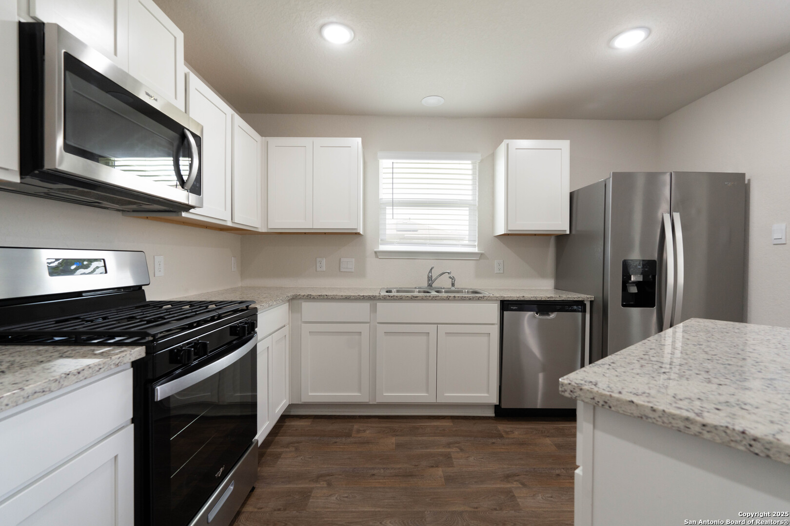 6806 Rondo Measure San Antonio, TX 78252 - Photo 14 of 25 a kitchen with stainless steel appliances granite countertop a sink stove microwave and refrigerator