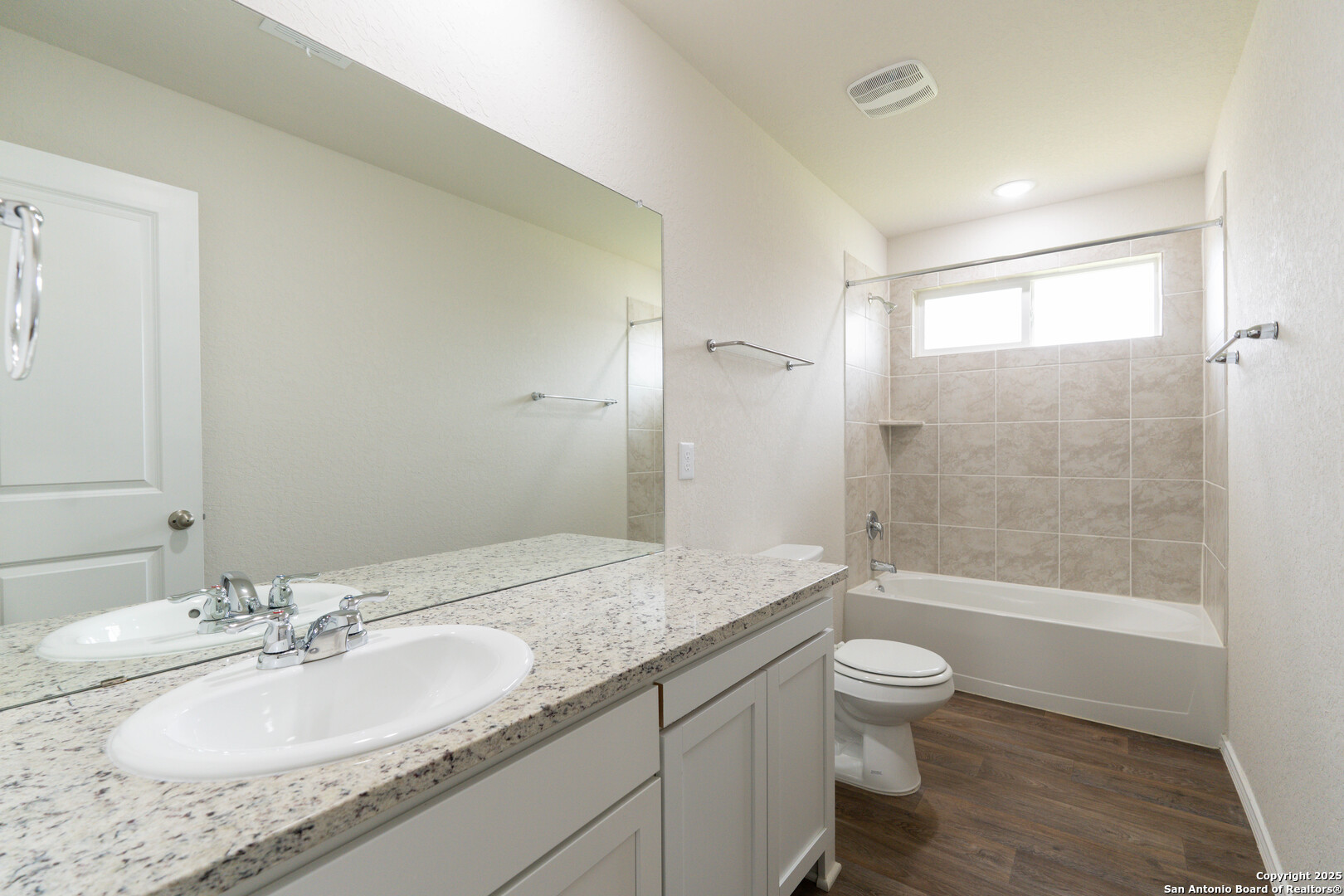 6806 Rondo Measure San Antonio, TX 78252 - Photo 18 of 25 a bathroom with a granite countertop sink a toilet and shower