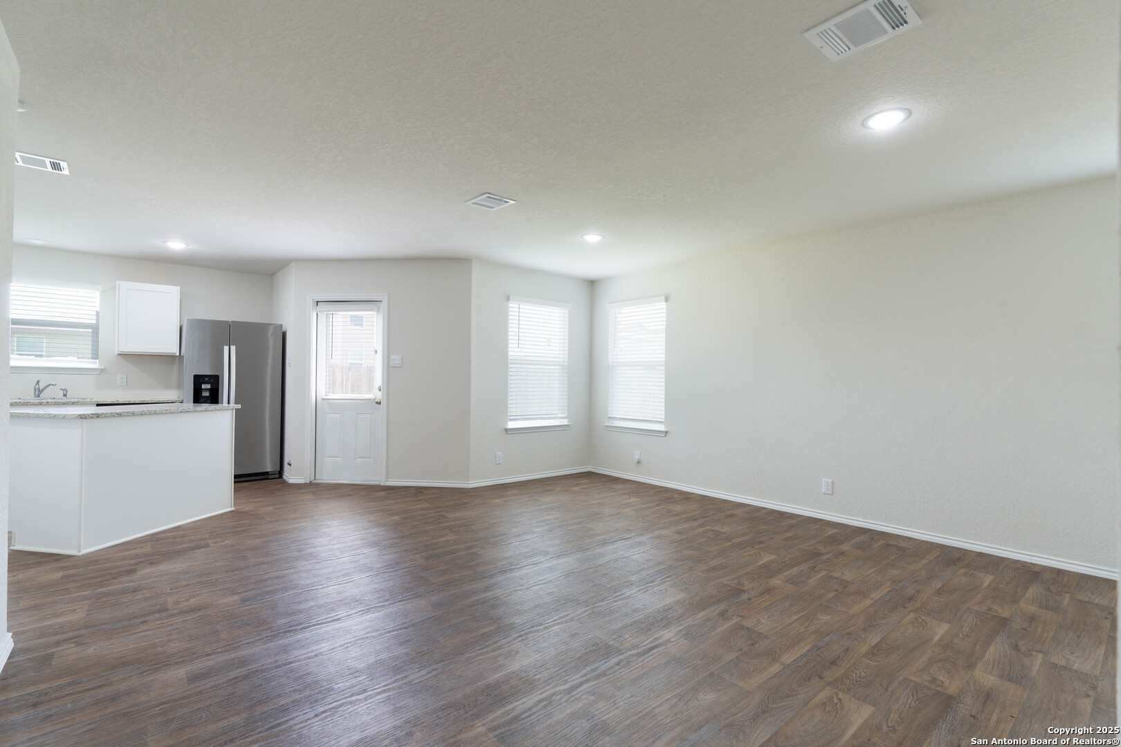 6806 Rondo Measure San Antonio, TX 78252 - Photo 10 of 25 a view of an empty room with window and wooden floor
