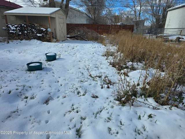 a view of backyard with wooden fence