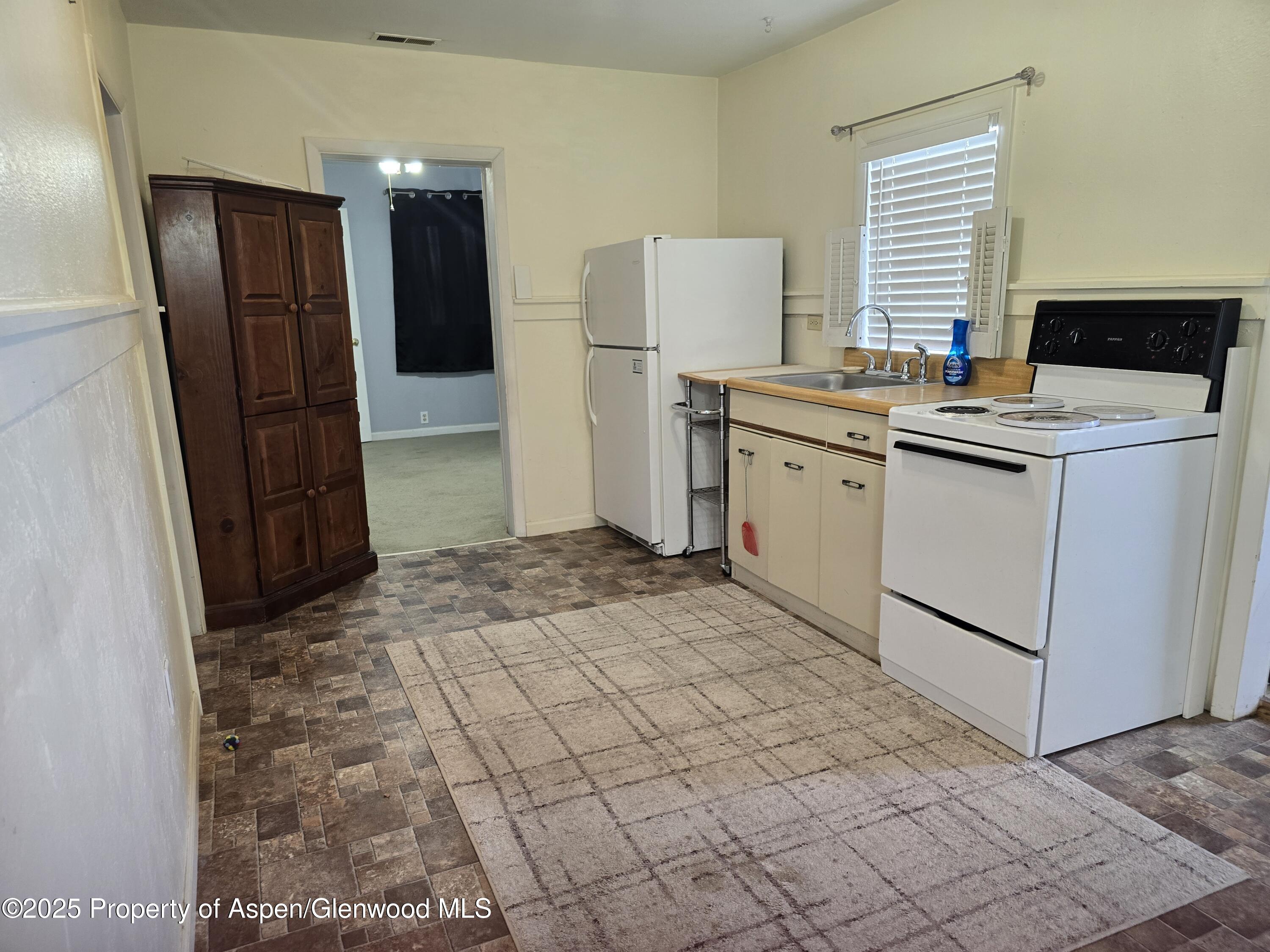 354 School Street Craig, CO 81625 - Photo 4 of 26 a kitchen with a refrigerator and a stove top oven