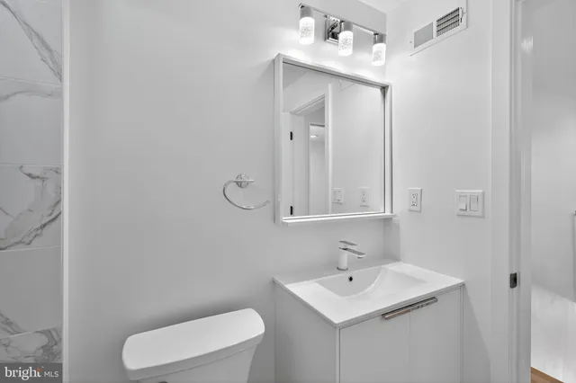 a bathroom with a toilet sink and mirror