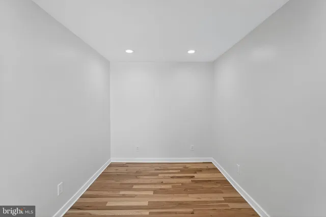 a view of a room with wooden floor and white walls