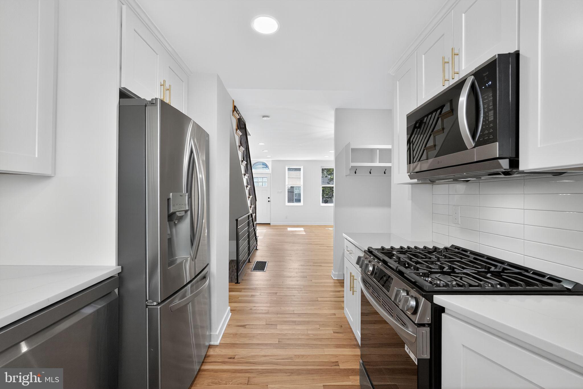 615 Sigel Street Philadelphia, PA 19148 - Photo 7 of 28 a kitchen with stainless steel appliances granite countertop a refrigerator and a stove top oven