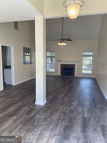 an empty room with a fireplace and wooden floor