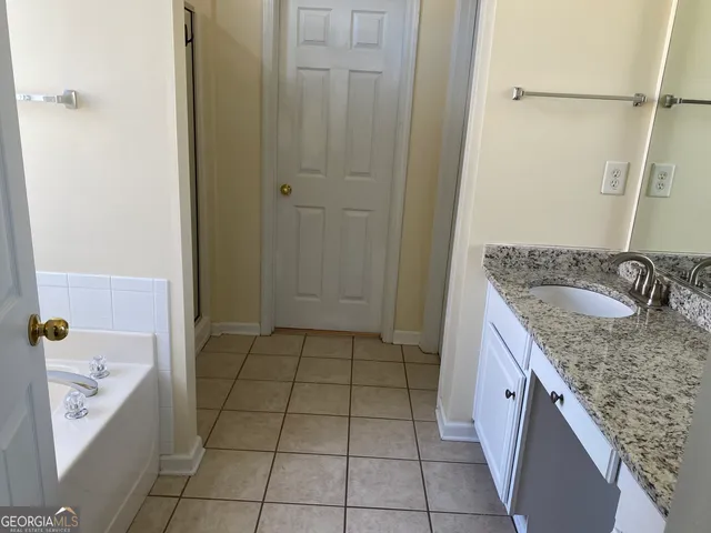 a bathroom with a granite countertop sink a toilet and shower