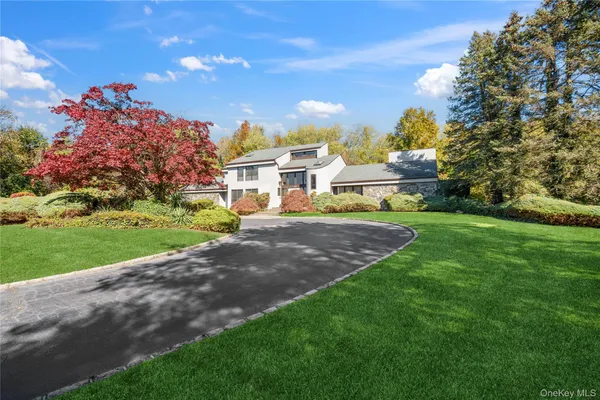 a view of a house with a big yard and a large tree