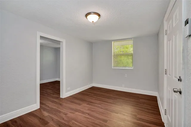 a view of an empty room with wooden floor