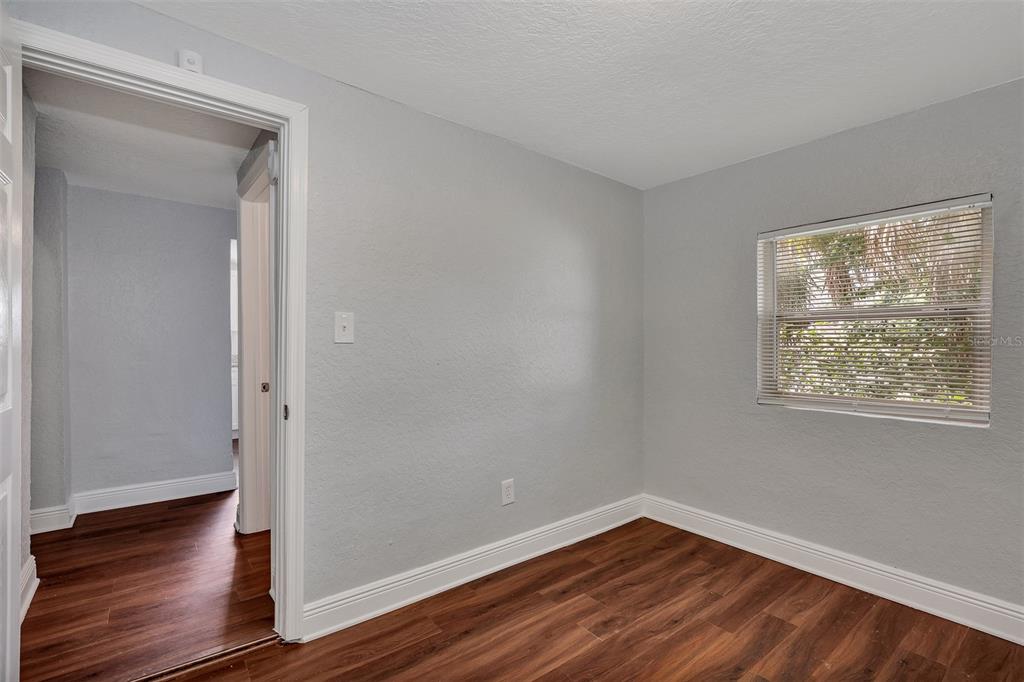 3106 North 17th Street, Unit C Tampa, FL 33605 - Photo 8 of 12 a view of an empty room with wooden floor and a window