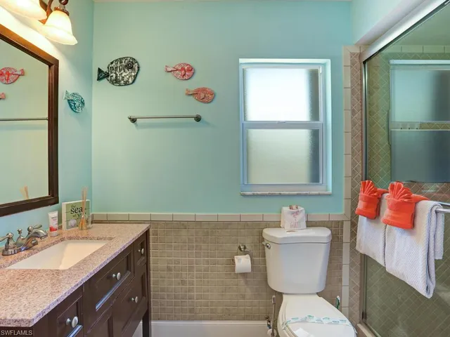 a bathroom with a sink mirror vanity and toilet