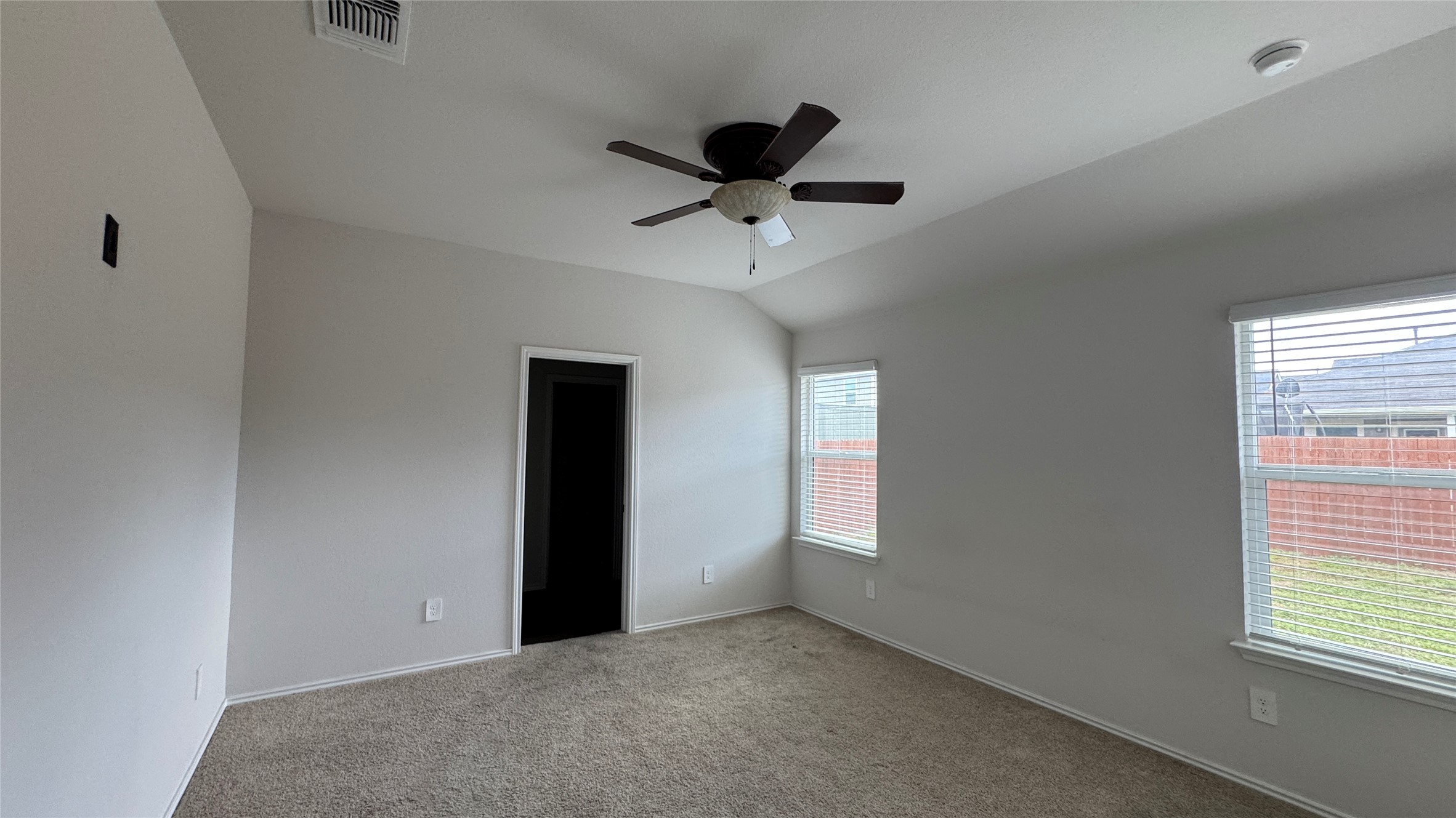 408 Frogmore Loop Kyle, TX 78640 - Photo 13 of 32 A comfortable bedroom features plush carpeting and abundant natural light from wide windows.