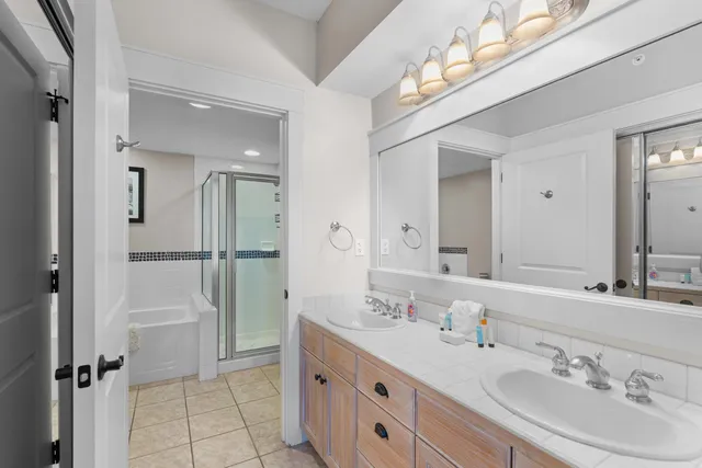 a bathroom with a tub a sink a mirror and a shower