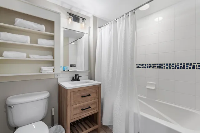 a bathroom with a sink toilet vanity and tub